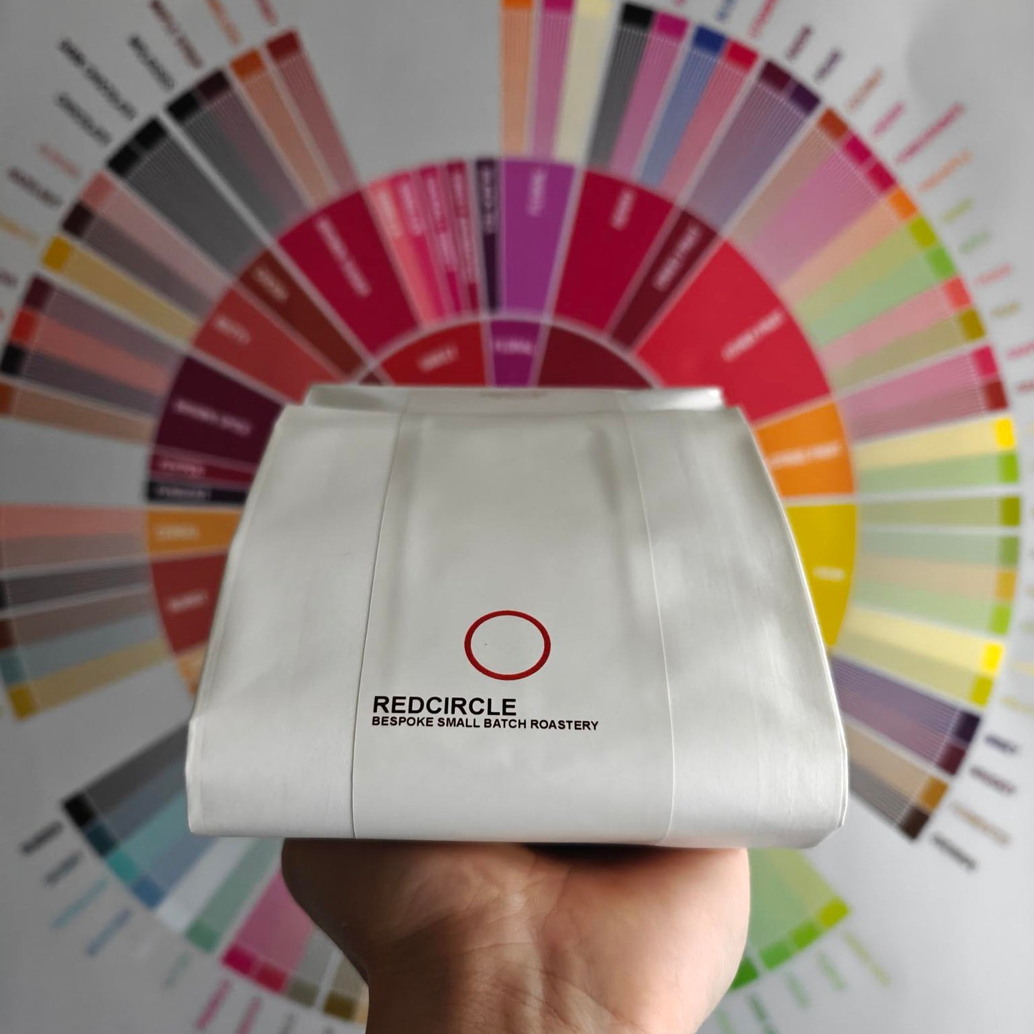 White bag with 'Redcircle' branding held in front of a color wheel
